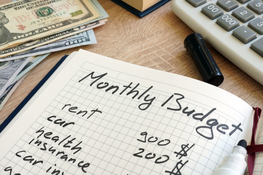 Note pad with monthly budget items written on it